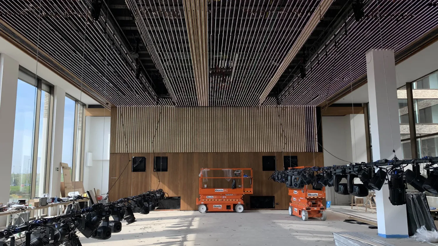 Rendu final immersif du projet. Le plafond et le mur LED sont allumés et diffusent un motif vidéo abstrait bleu et violet, tandis que les projecteurs scéniques éclairent la scène avec des faisceaux chauds.